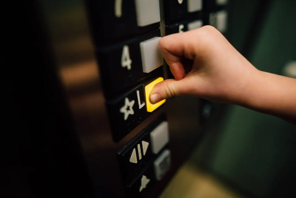 A finger pressing an elevator lobby button